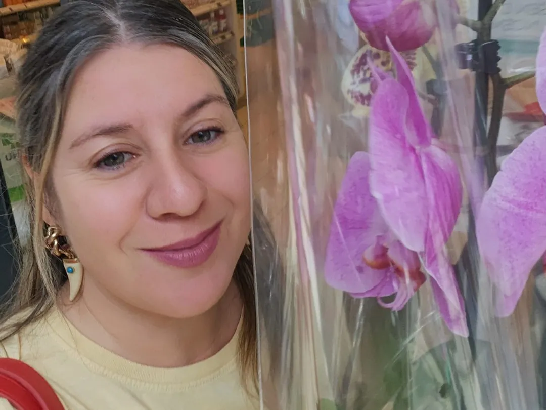 Cecilia junto a unas orquídeas en un vivero